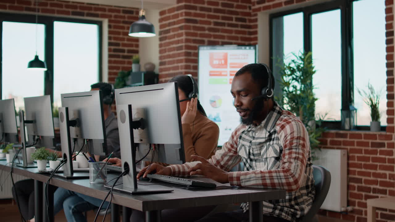 Male employee answering telephone calls on headset