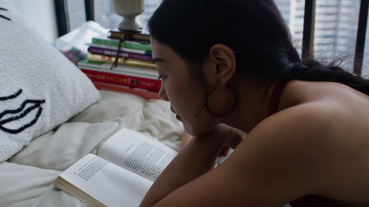 Donna che legge un libro vicino alla finestra