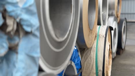 steel coils are stocked in the real warehouse. an industrial workshop and warehouse are needed for the storage and distribution of products from a metallurgical plant. type a