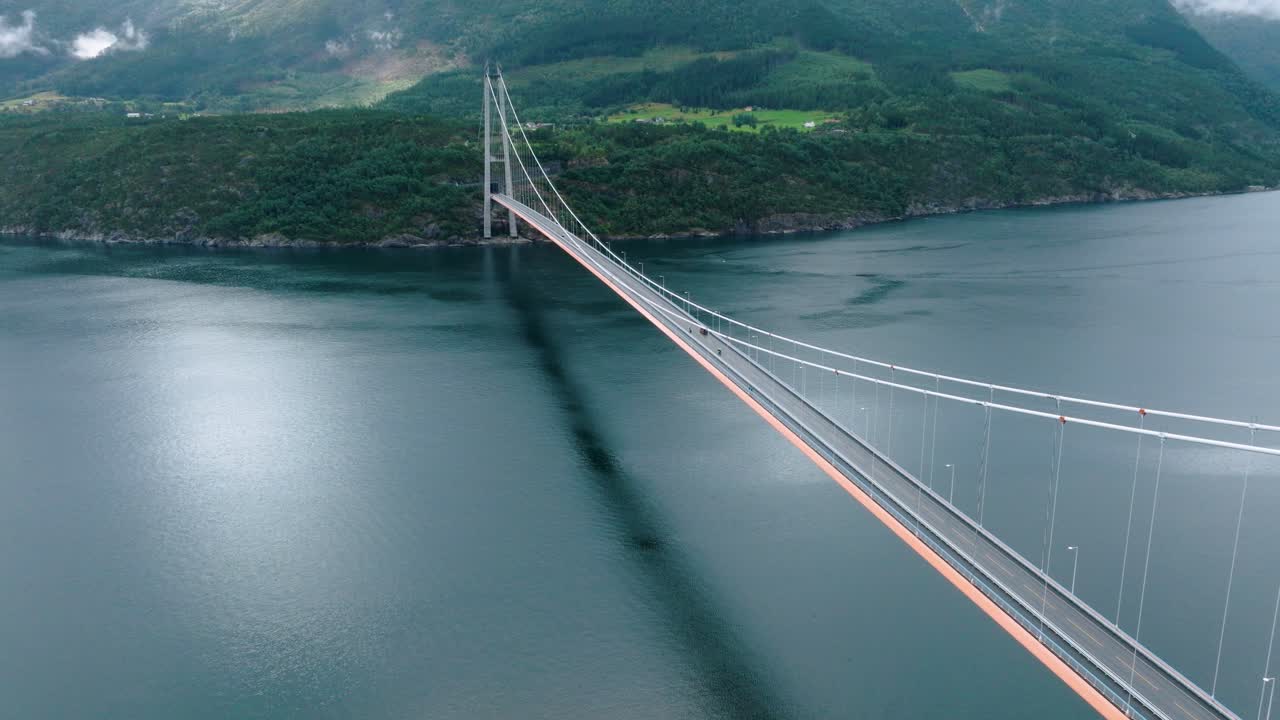 Cars driving on Hardanger bridge in Norway on cloudy moody day