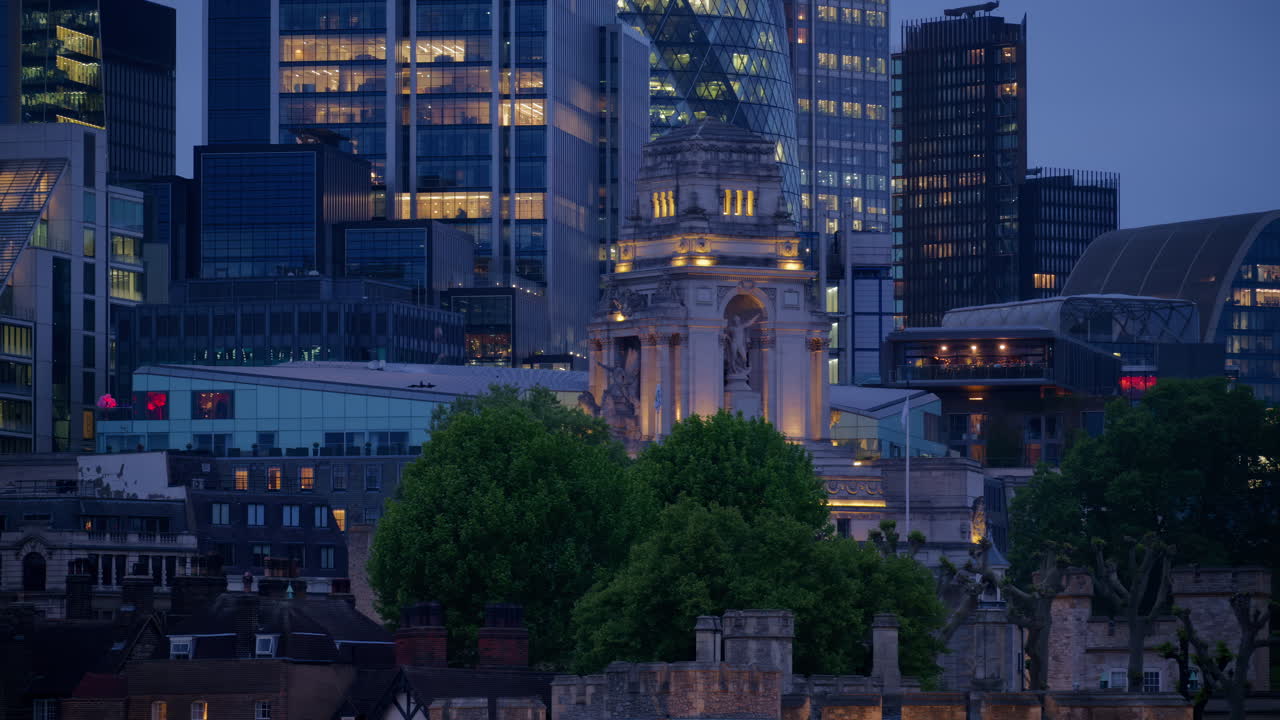 Close-up of a detailed building spire with gothic architectural features illuminated at night in London, England