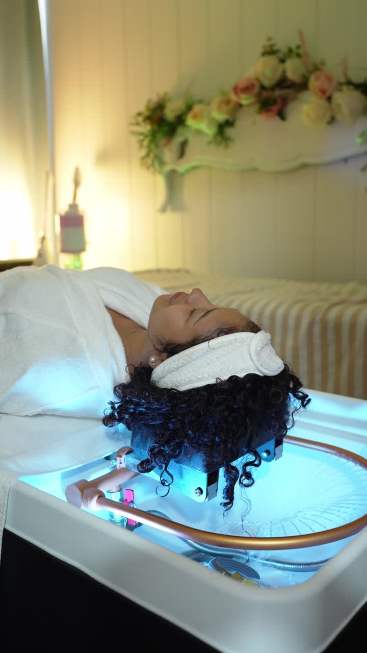 Mulher recebendo terapia facial com luz LED em um spa