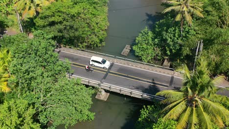 Statische-Luftaufnahmen-Von-Autos-Und-Motorrädern,-Die-über-Eine-Brücke-Auf-Einer-Tropischen-Insel-Fahren