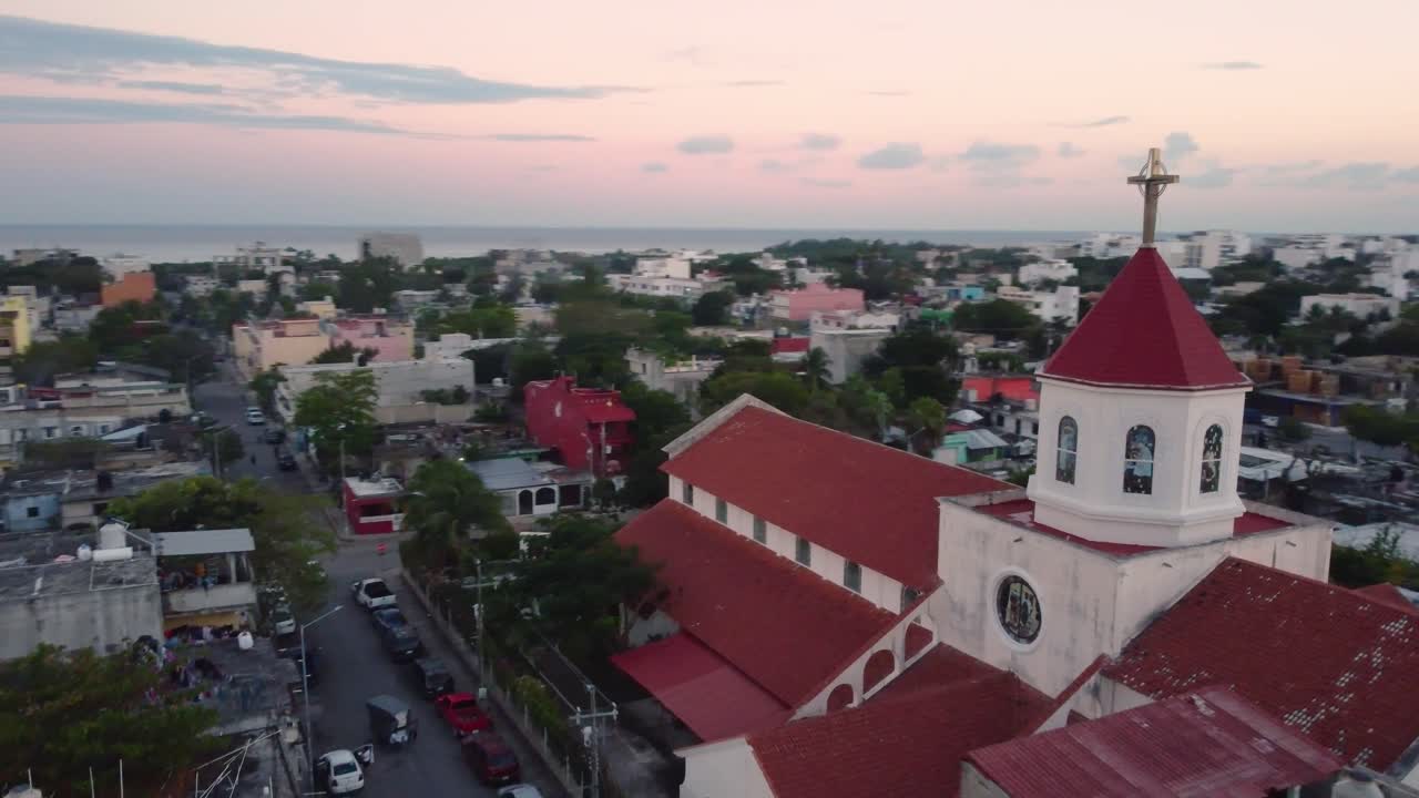 Church guardering a seaside city, and a sunset embracing the horizon and the sea, Mexico