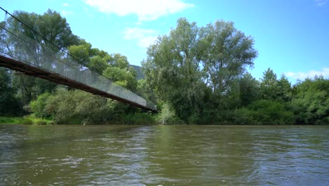 Drohnenschuss,-Der-An-Einem-Sonnigen-Sommertag,-Slowakei,-Unter-Der-Brücke-Auf-Dem-Fluss-Fliegt