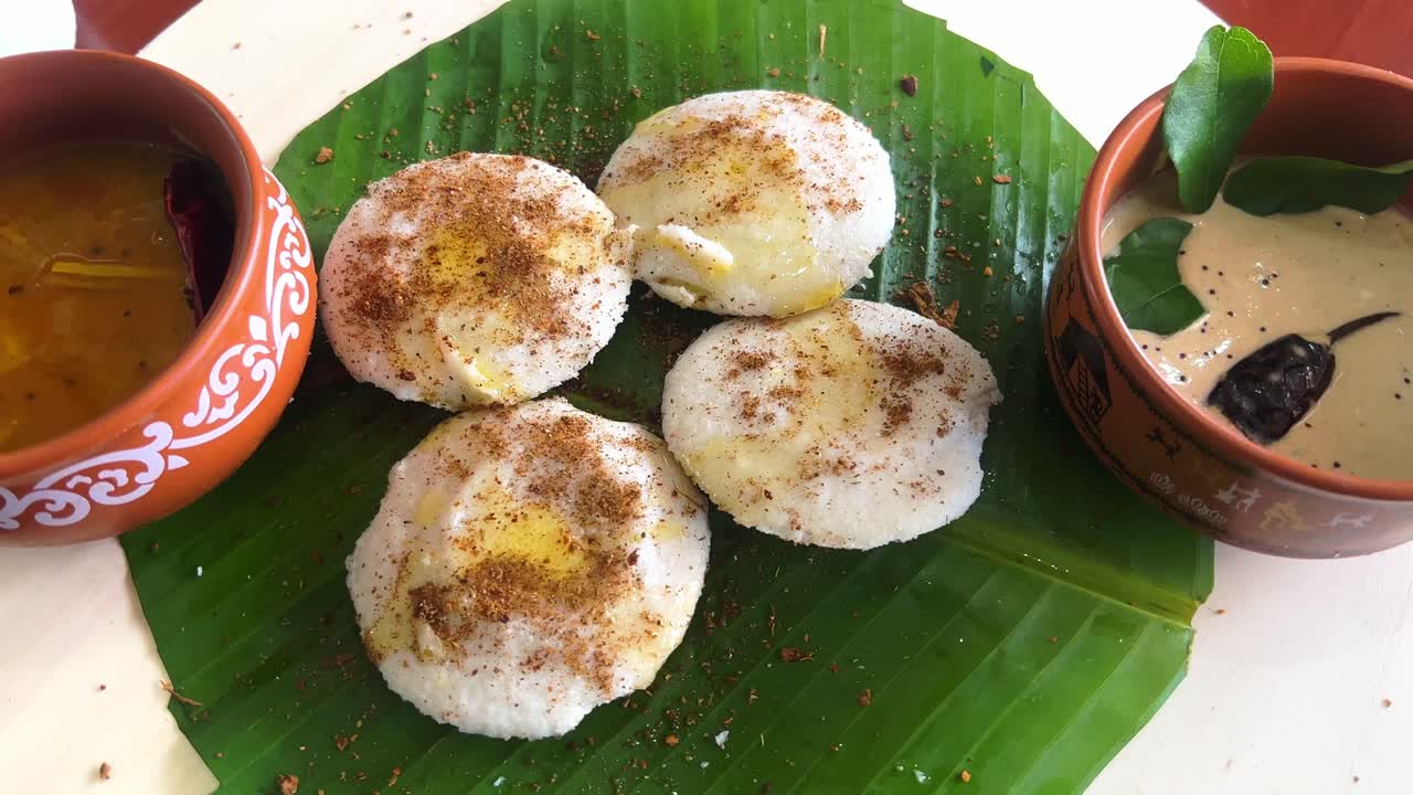 Podi Idly with some ghee on a banana leaf with peanut chutney and sambar