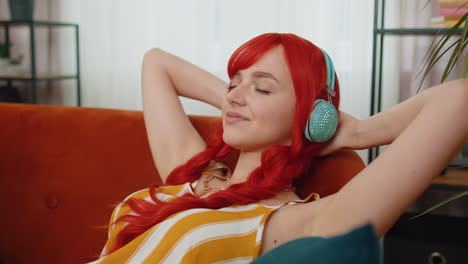 Chica-Con-Auriculares-Inalámbricos-Escuchando-Música-Disco-Favorita-Relajante-Durmiendo-Descansando-En-El-Sofá-De-Casa