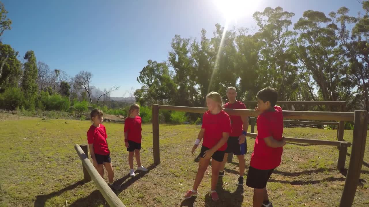 장애물 코스 4k 동안 피트니스 트레일에서 여학생을 돕는 트레이너