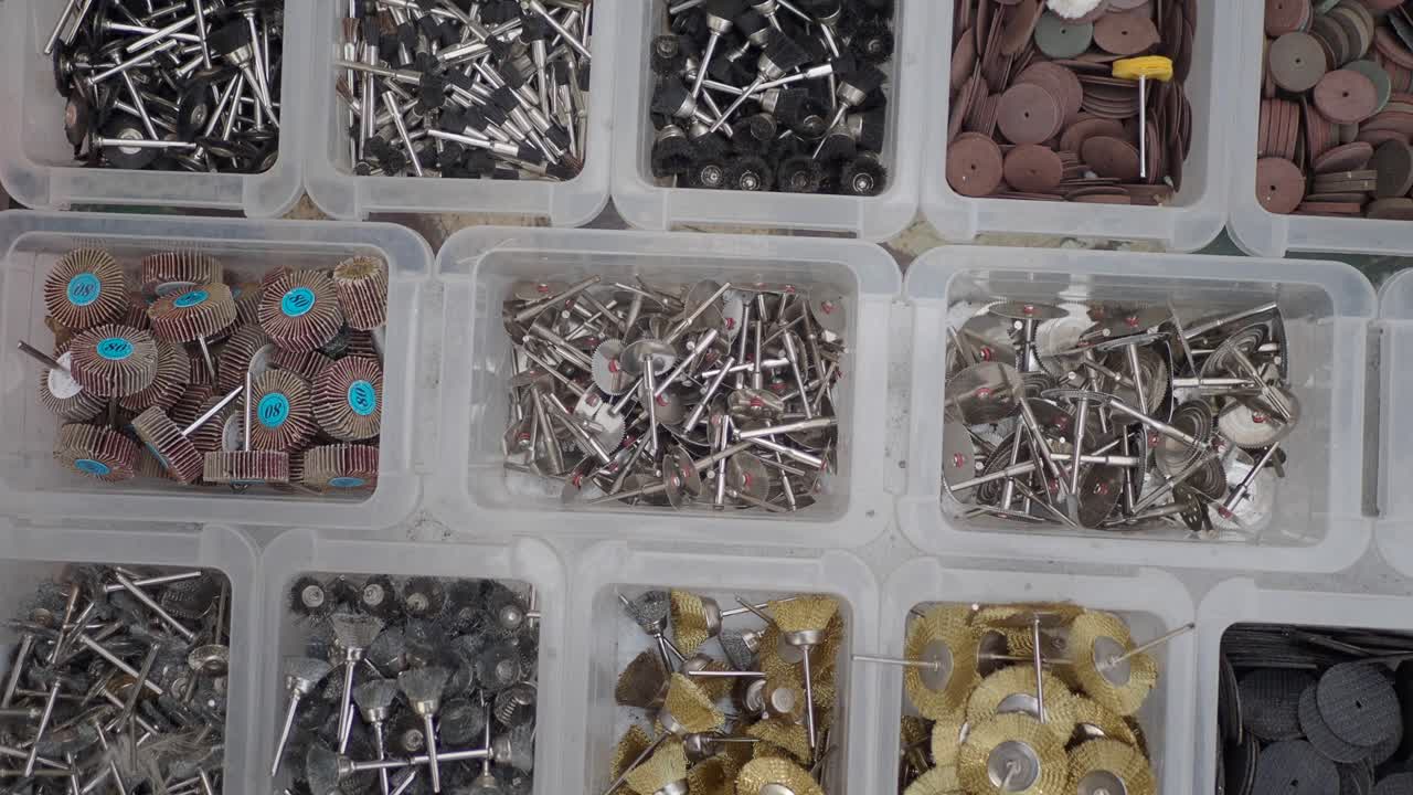 variedad de pequeñas herramientas de molienda y pulido en envases de plástico