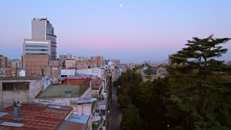 Aerial-Drone-Fly-above-Fine-Arts-neighborhood-in-Santiago-de-Chile-Sunset-Moon-Skyline-with-vibrant-colors,-houses-in-latin-american-cityscape