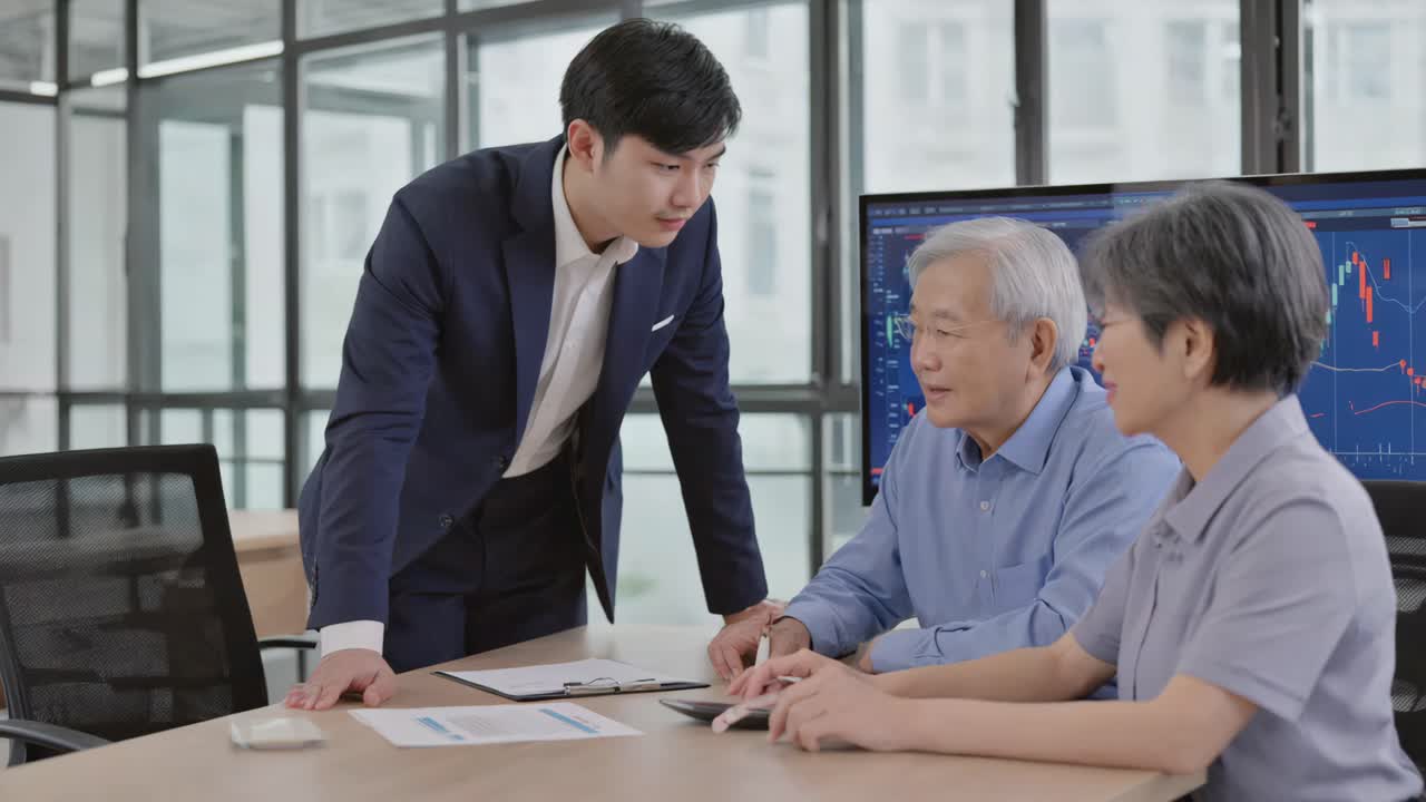 Financial advisor discusses investments with a senior couple in an office