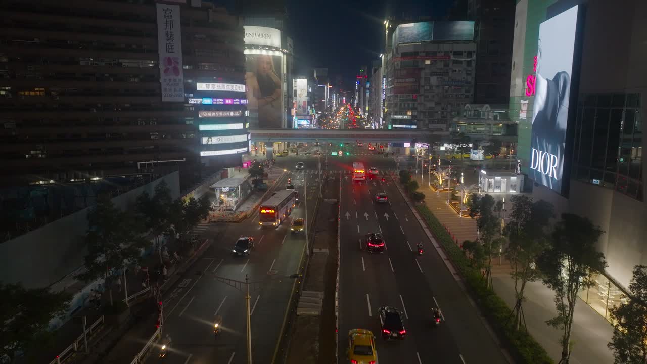 Aerial view of main street with busy traffic at night in downtown of Taipei, Taiwan. Sogo Building with digital Advertising Panel. Environmental Pollution theme.