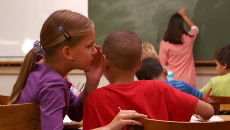 Niños-De-Escuela-Susurrando-Durante-La-Clase