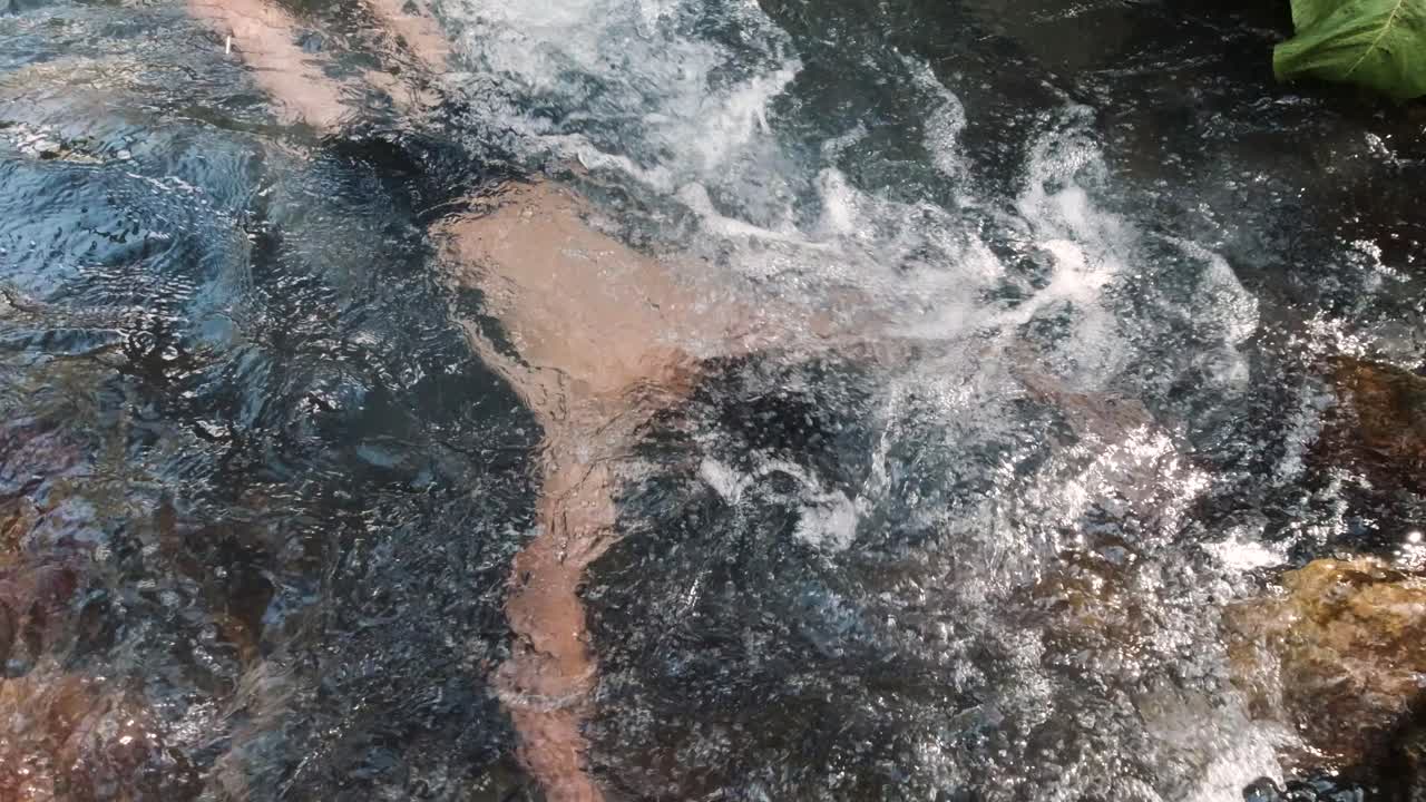 Persona che nuota in un fiume impetuoso