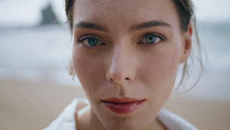 mujer de primer plano posando en la playa. retrato de mujer tranquila con ojos verdes al aire libre.