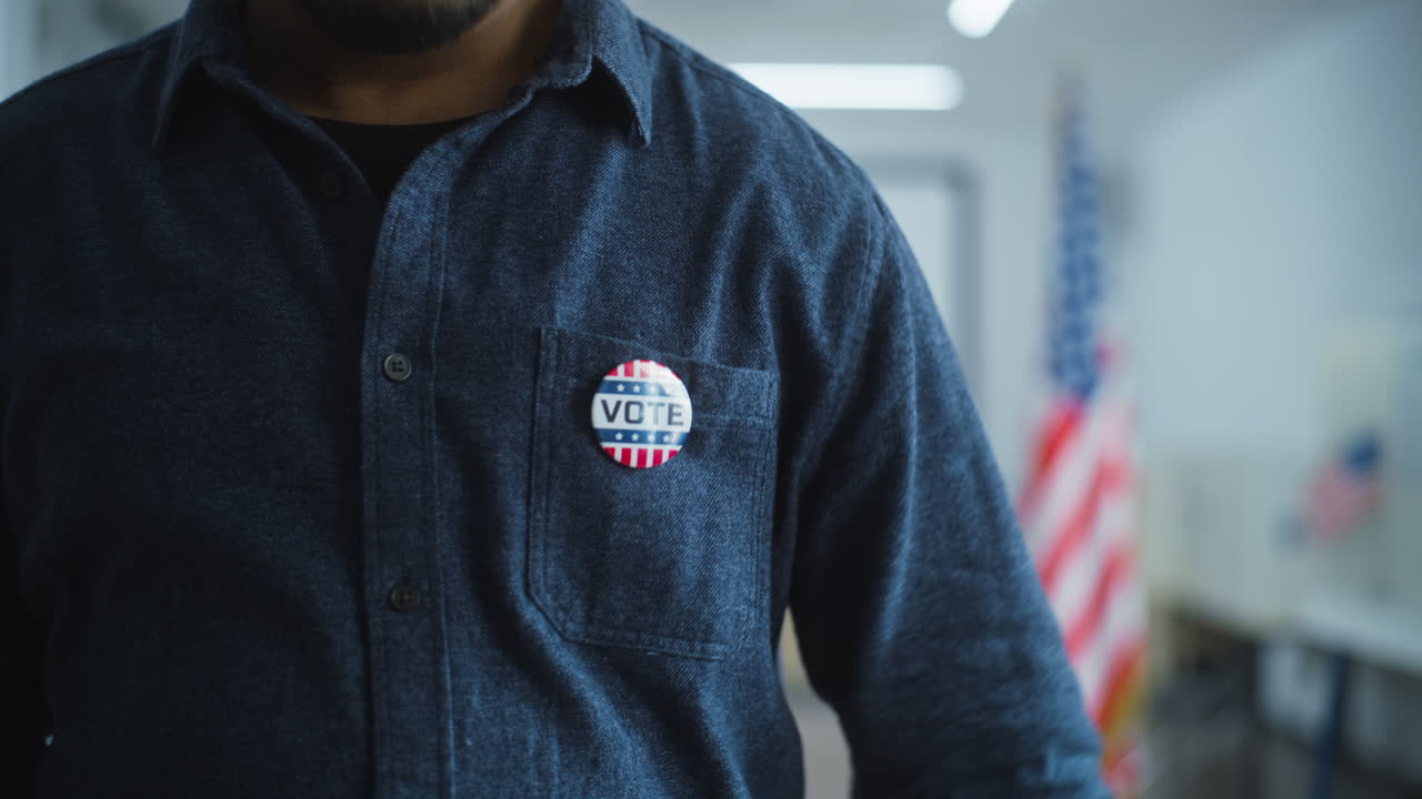 African American Businessman Puts on Badge during Elections Anonymous African American Male Voter or Businessman Puts on Badge with Usa Flag Logo and Inscription i Voted us Citizen at Polling Station during Elections National Election Day in United States