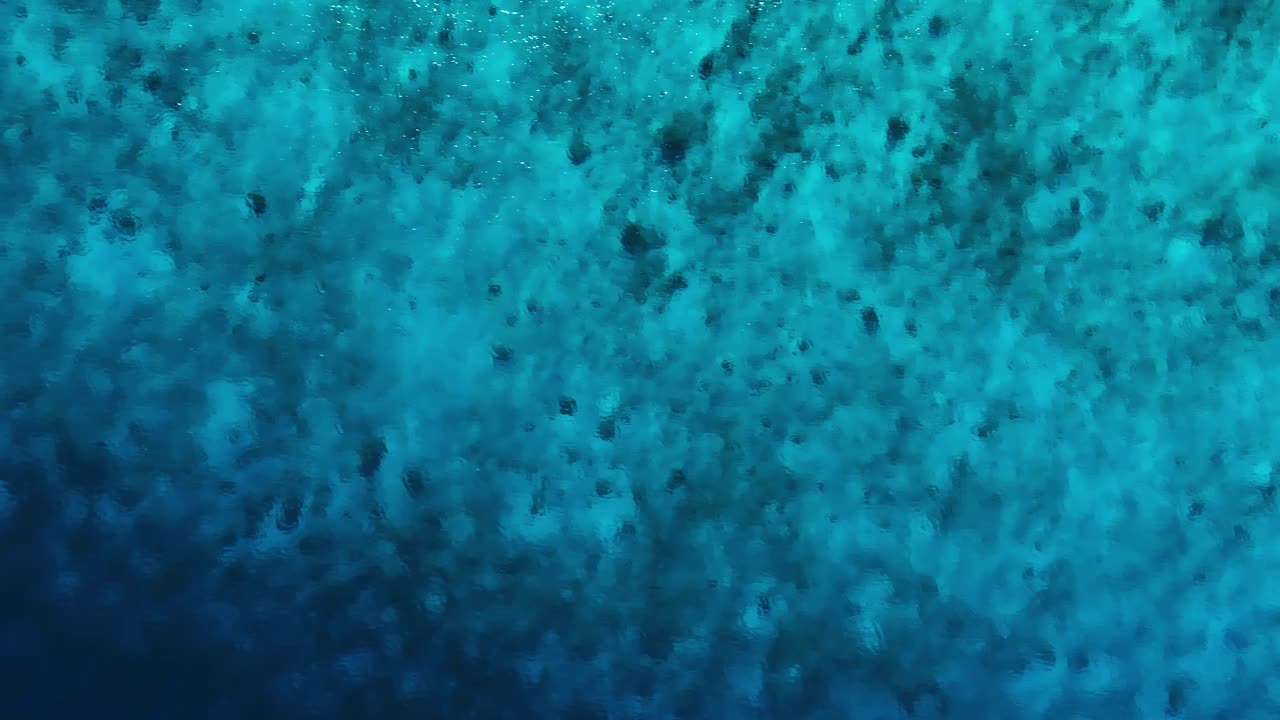 Vista de dron cenital de las ondas en las aguas turquesas del Caribe.