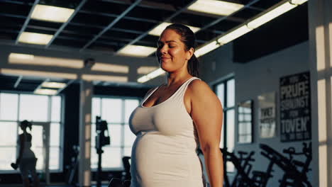 plus-size pregnant woman working out in gym