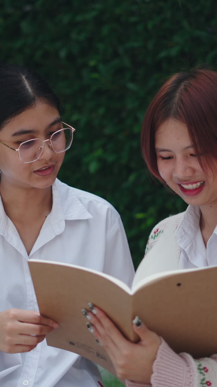 Two students reading a notebook