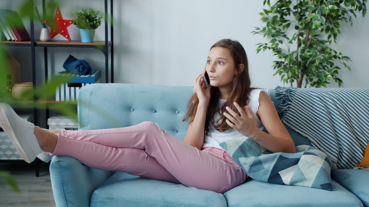 Teenage Girl Relaxing on Couch and Talking on Phone