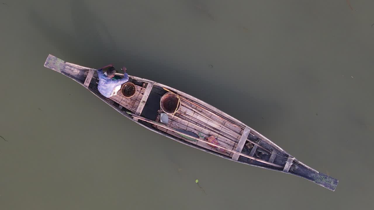 vista aérea de un pescador solitario en un barco de madera tradicional pescando con hilo flotante