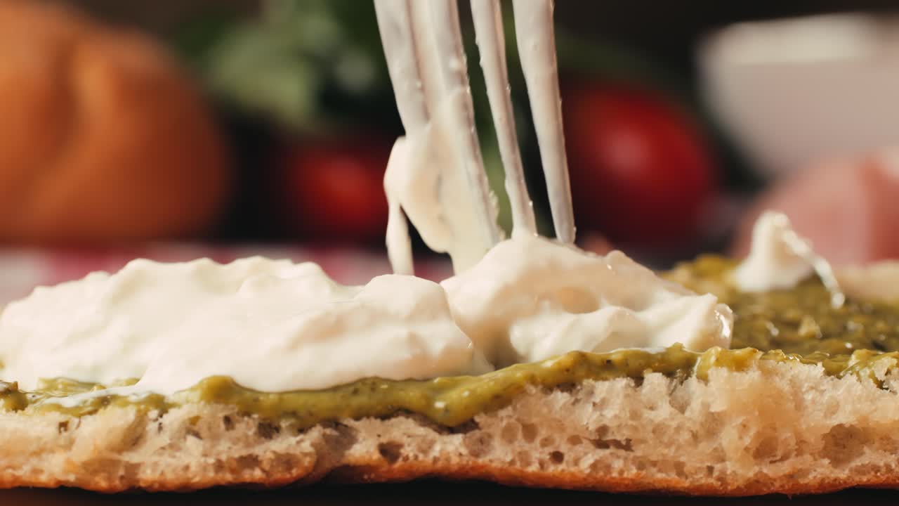 Mortadella ham sandwich, Traditional italian focaccia filled with thin pesto slices of mortadella, served by chef man in cafe restaurant. Macro of traditional italian spanish tapas antipasti.
