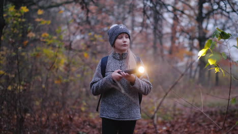 a little girl walks through a dark forest with a flashlight in her hand get lost in the forest conce