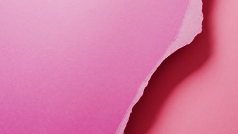 video de un primer plano de pedazos de papel rosa rasgados con espacio de copia en el fondo