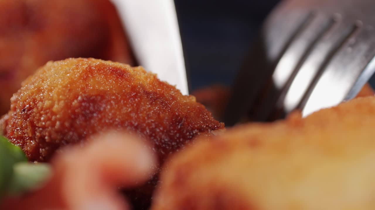 Spanish tapas, Fried portuguese croquettes close-up macro. Breaded croquette of fish, potatoes and ham. Man cooking spanish food.