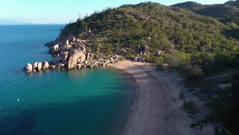 Magnetic-Island-Arthur-Bay-empty-beach-aerial-with-tree-shadows-and-boulders,-Queensland