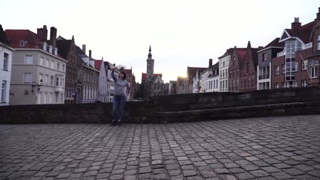 girl tourist makes selfi on a smartphone on a background of the city of bruges belgium