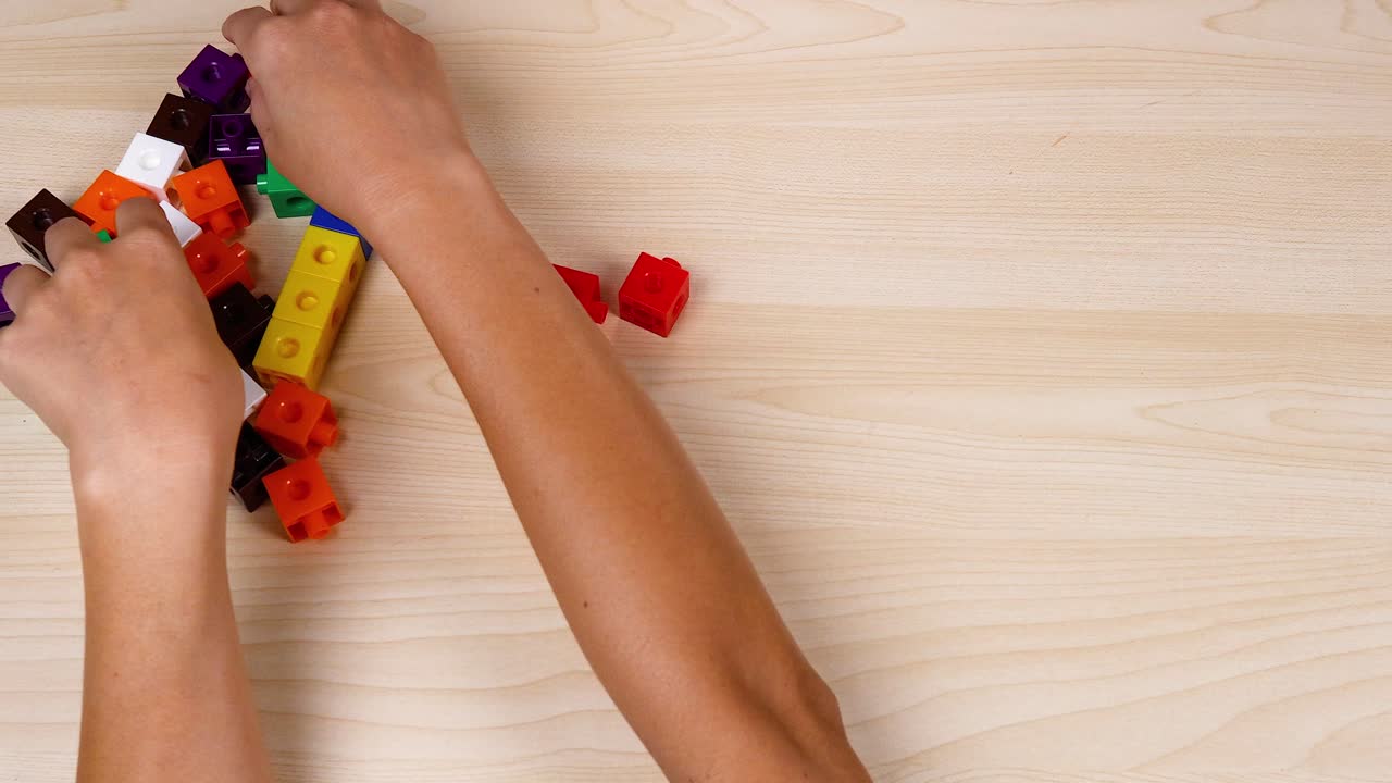 manos montando coloridos cubos de enlace en la mesa
