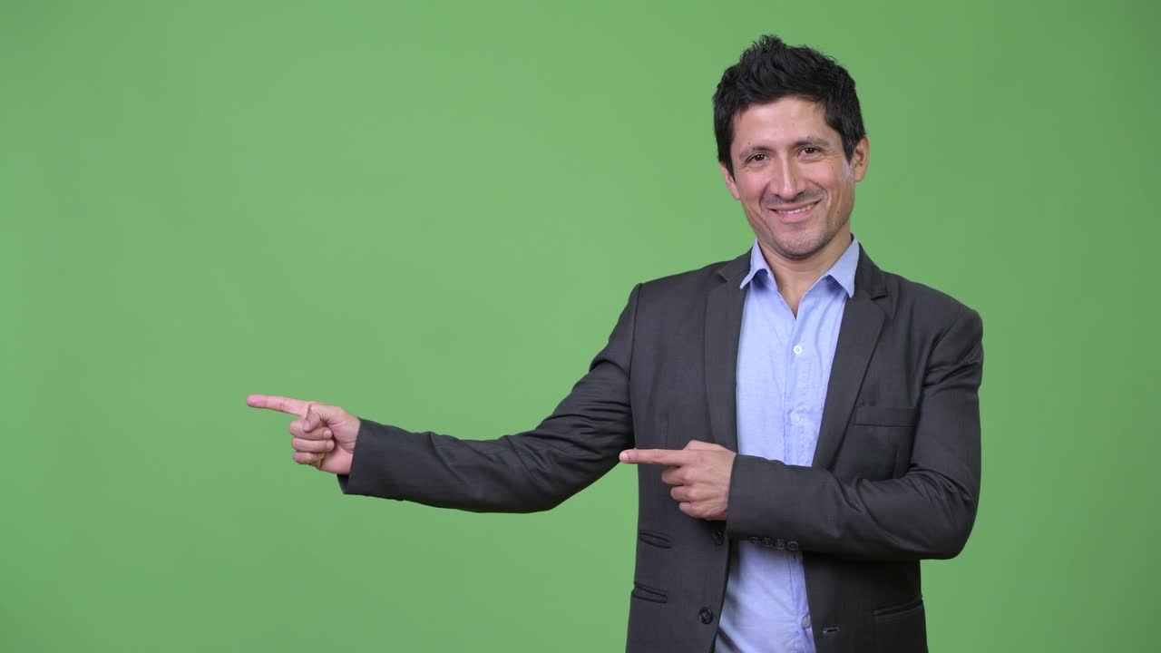 Happy Hispanic businessman showing something