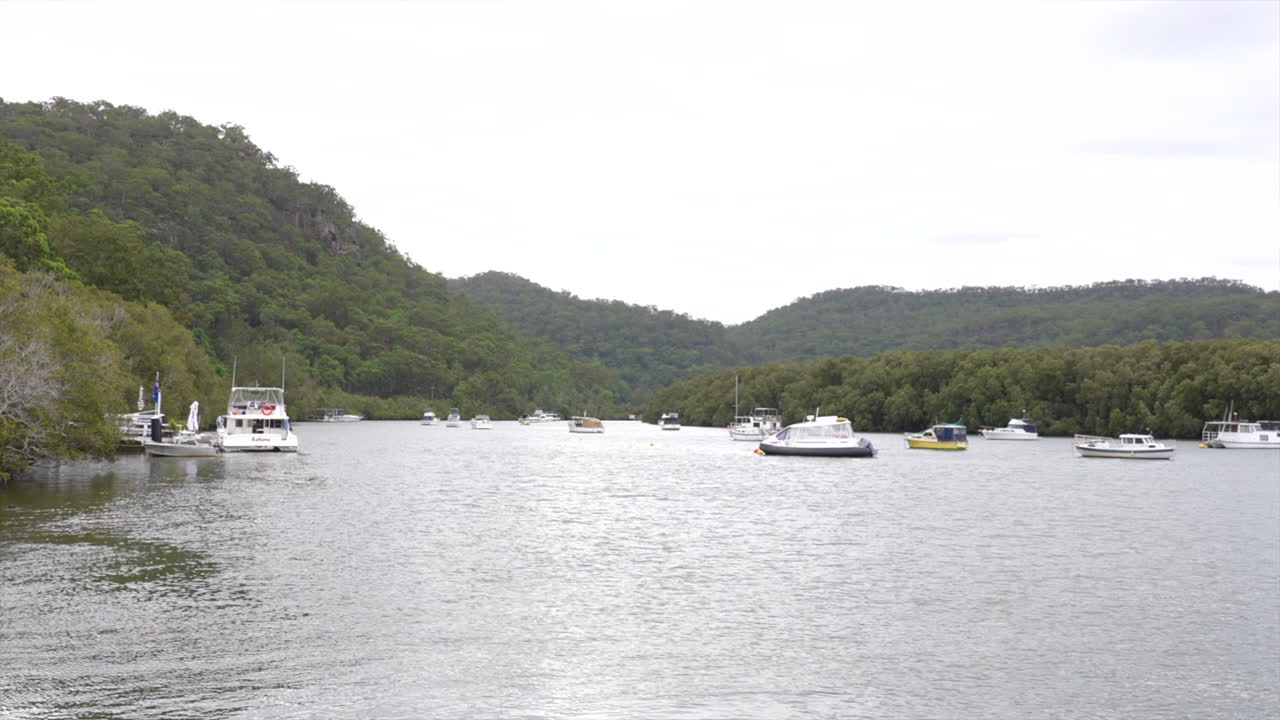 Multiple boats and vessels moored up on the Hawkesbury River, Spencer, NSW, Australia