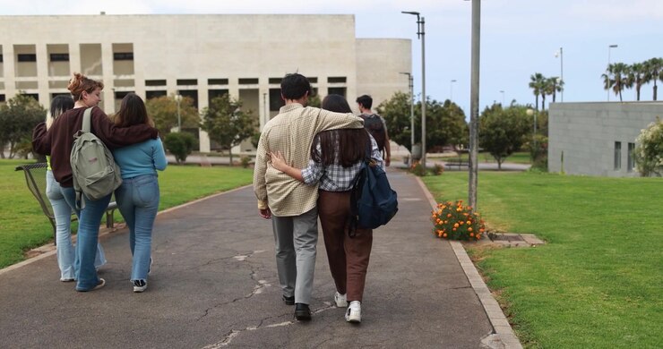 Gruppo di studenti che cammina insieme nel campus universitario