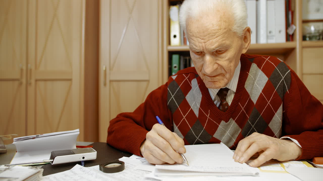 empresario senior escribiendo en papel en la mesa en la oficina 16