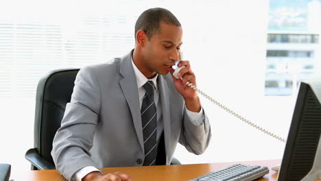 businessman working at his desk and talking on phone