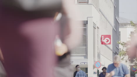 pedestrians mull around torggata pedestrian street past statue of labourer, oslo