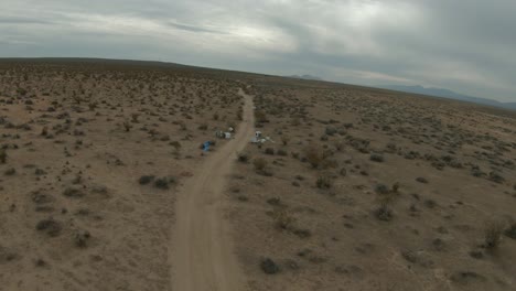 flying over the desert to where unscrupulous people unlawfully dumped broken appliance and other trash along the road