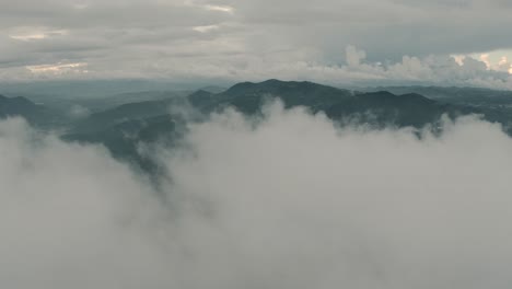 drone aerial flying over clouds revealing a beautiful landscape with mountains in guatemala