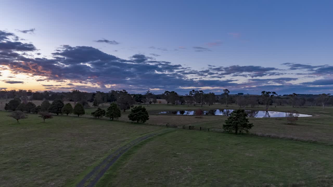 Sunset flyover hyperlapse of a pretty lake on farmland in Southern NSW