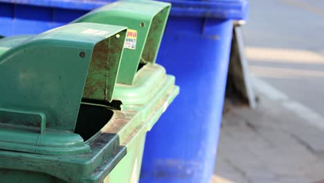 mujer tirando una botella de plástico en el contenedor de basura