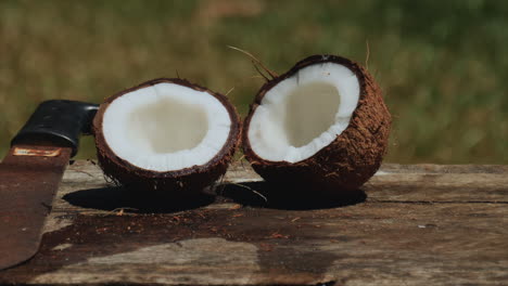 un coco partido por la mitad con un machete listo para comer la carne fresca y húmeda - vista deslizante