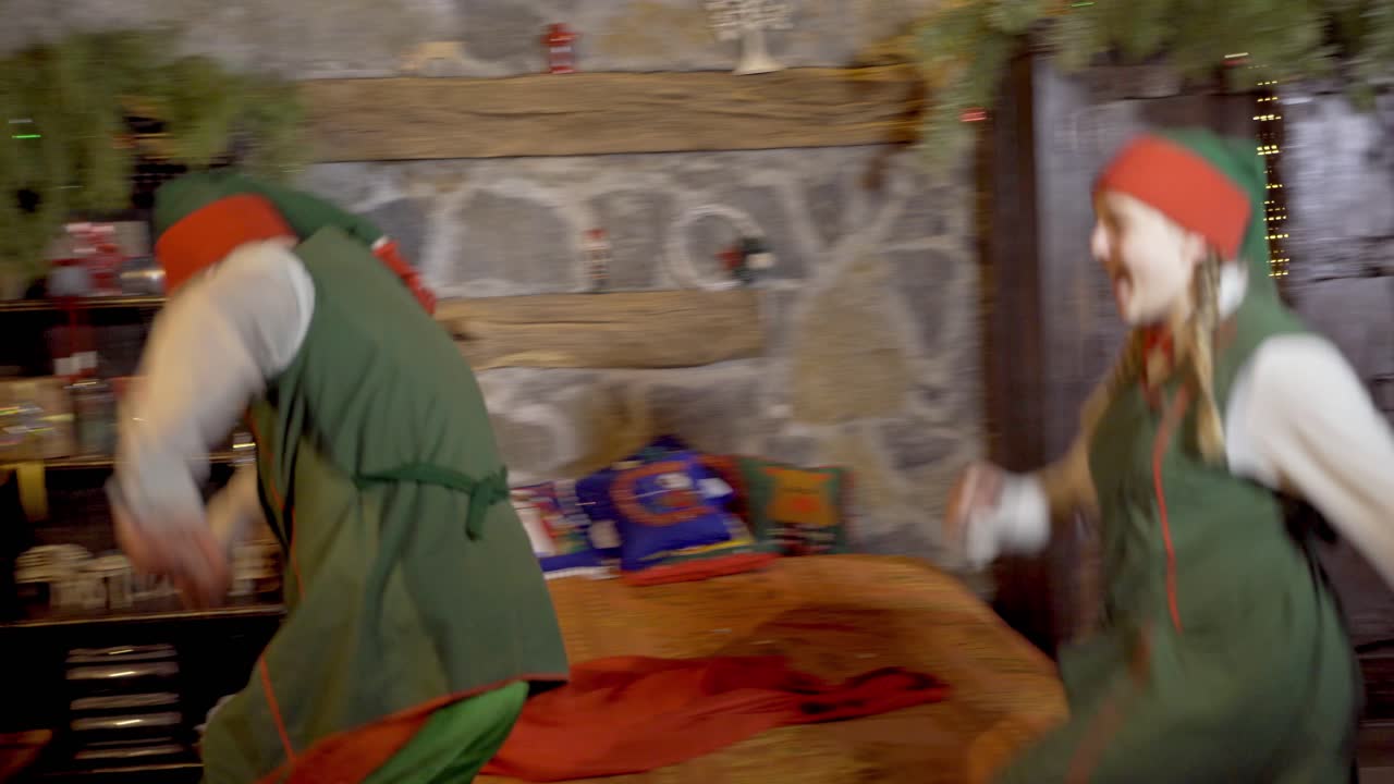 Santa Claus with elves in room. Santa Claus preparing for Christmas with adult elves