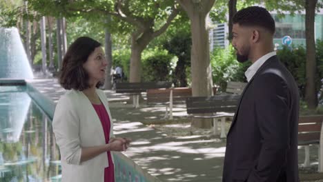 Two-business-partners-shaking-hands-and-talking-outdoor.