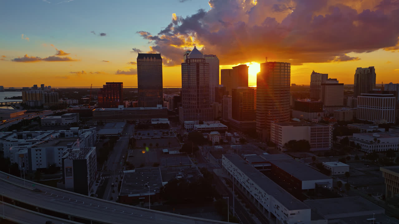 Vista aérea panorâmica do horizonte da cidade de Tampa ao pôr do sol e reflexos de lente quando o sol brilha entre os edifícios