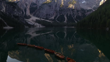 Flying-over-rowboats-on-a-reflecting-lake-revealing-towering-alpines-of-Tyrol---Aerial-view