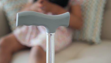 close-up of a walking cane with a blurry child in the background