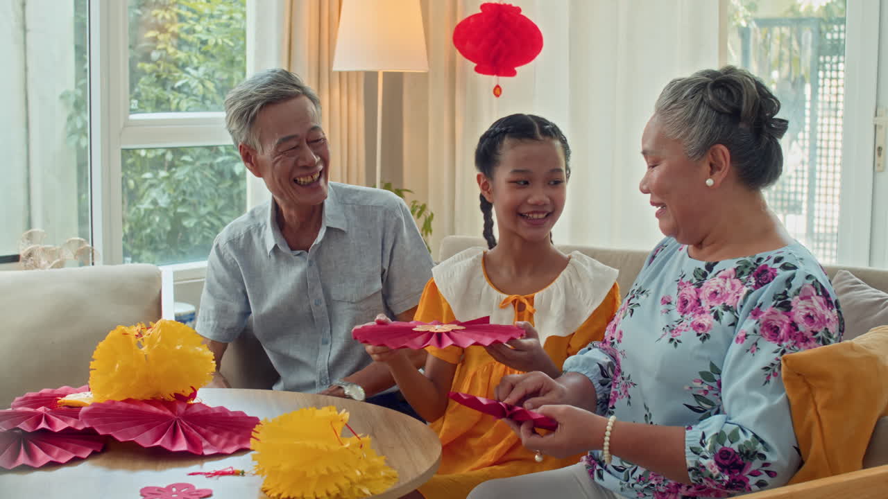 Teenage Girl Making Tet Decorations with Grandparents