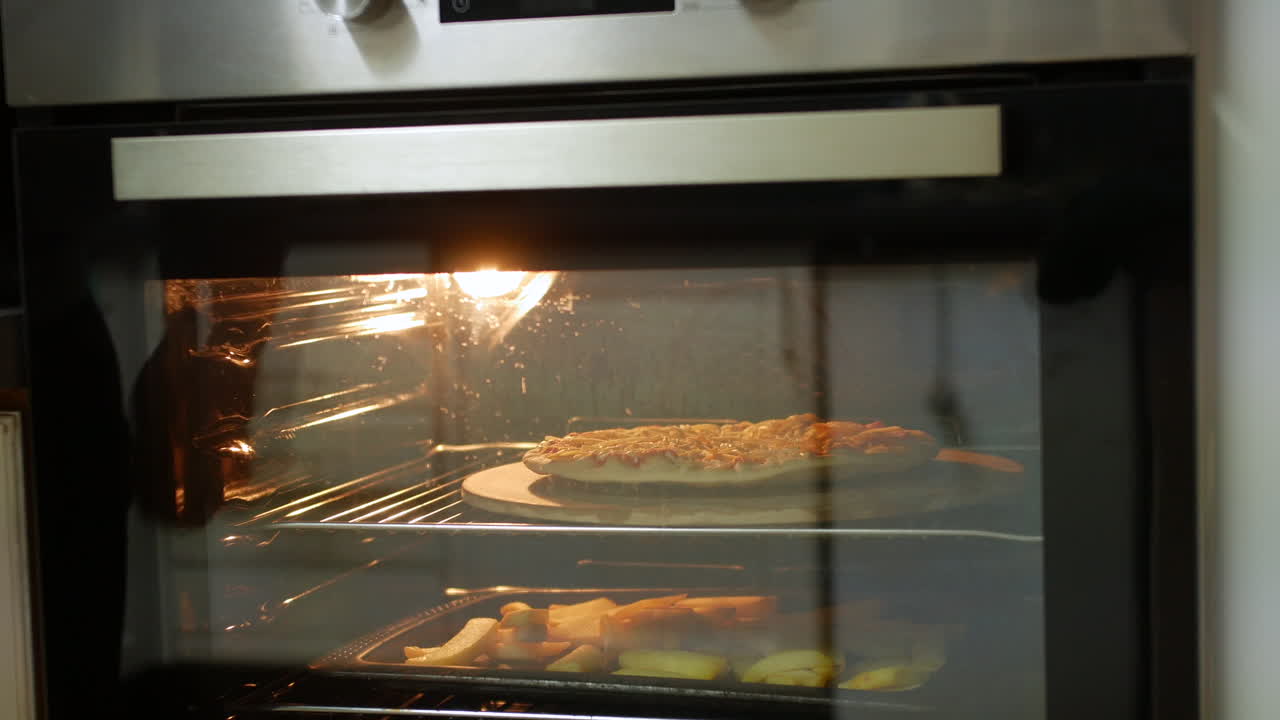 Someone places a pizza into an oven onto a pizza stone